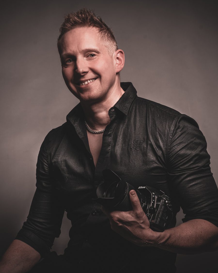 Tommi Palosaari kameran kanssa — studiomuotokuva