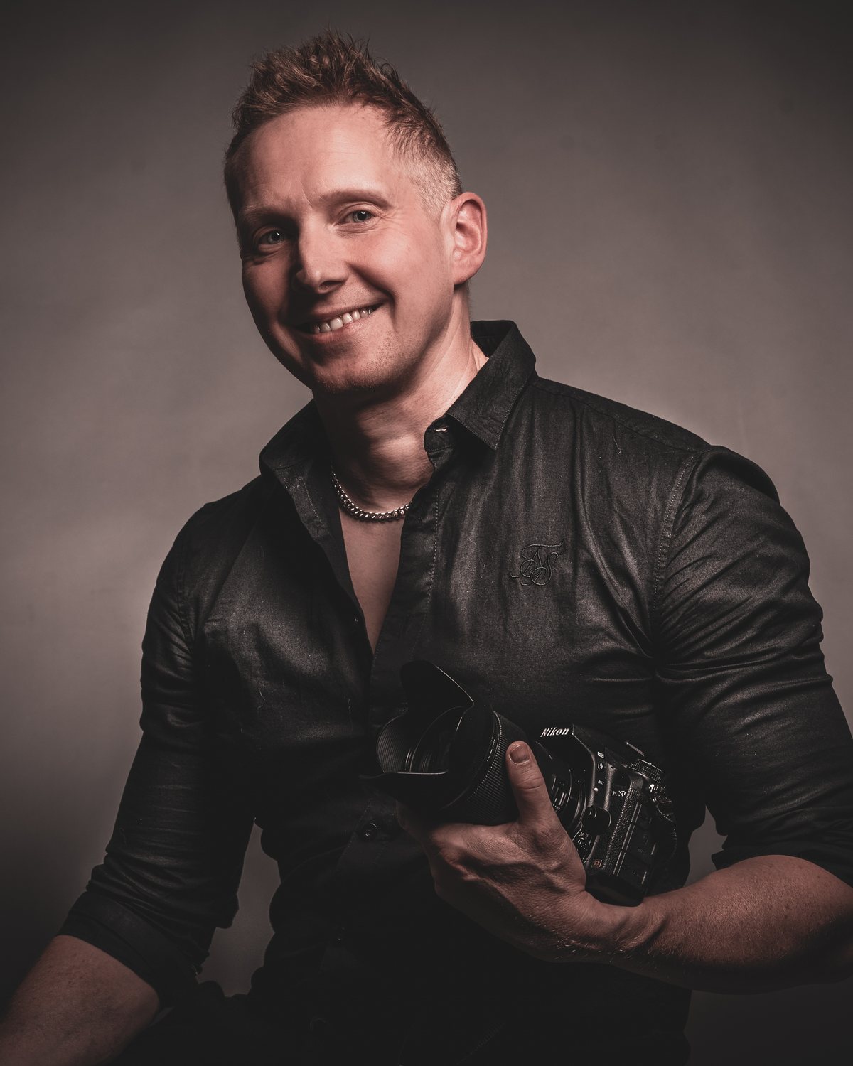 Tommi Palosaari kameran kanssa, studiomuotokuva